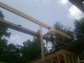 Carpenter setting a ridge beam over a new addition frame — Ice Dam Removal by Roofing Brothers in East Falmouth