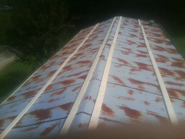 Rusted metal roof panels with new wood purlins before replacement — Storm Damage Roof Repair in East Falmouth by Roofing Brothers