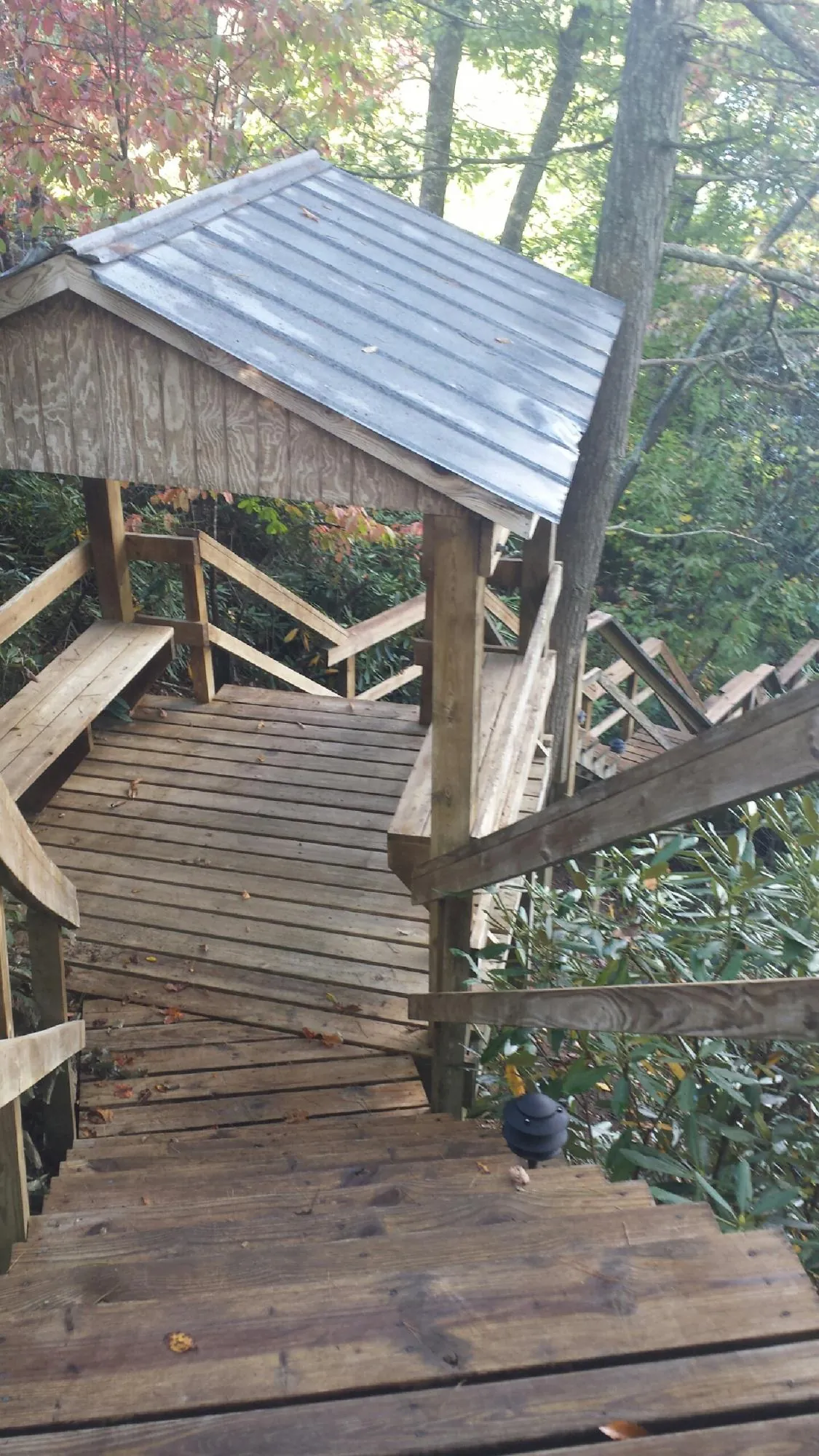 Metal roofed shelter over wooden steps on a wooded walkway — Skylight Repair & Installation work by our crew in East Falmouth