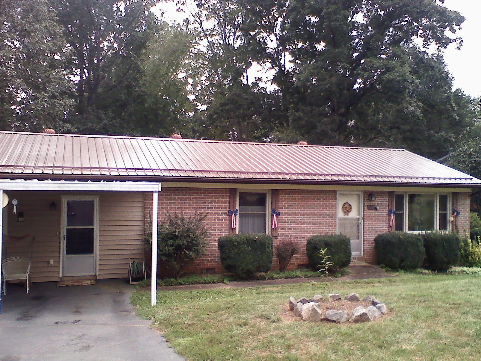 Bronze metal roof and carport on a brick ranch home — Roof Repair work by our crew in East Falmouth